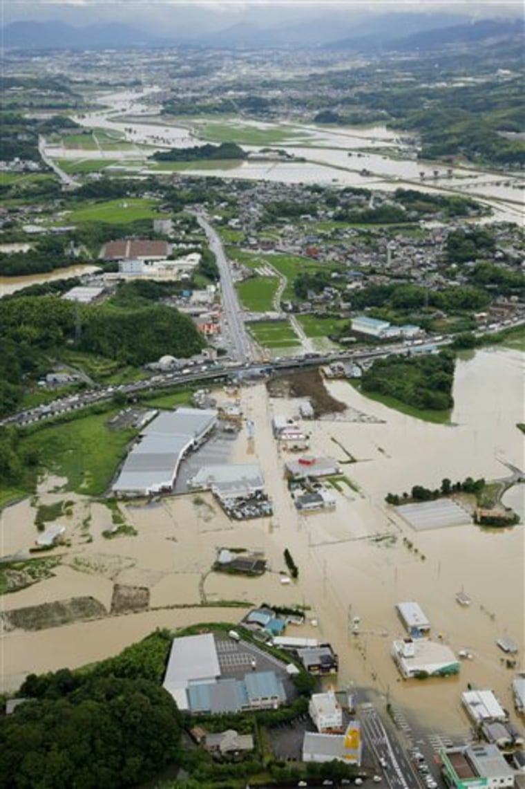 Houses and farmland are inundated by flood waters in Nogata, southern Japan, on Wednesday, July 14, 2010. Storms lashed southern and western Japan, leaving one dead and three missing. A woman drowned in a swollen river, and three people, including two women in their 70s, were missing, according to officials. Nearly 10,000 homes were evacuated. (AP Photo/Kyodo News) ** JAPAN OUT, MANDATORY CREDIT, FOR COMMERCIAL USE ONLY IN NORTH AMERICA **
